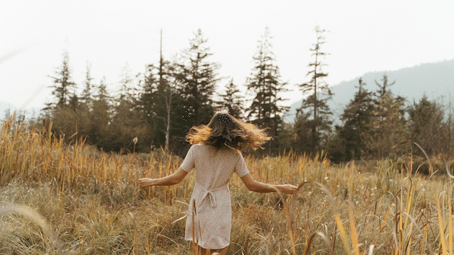 woman twirling in a field