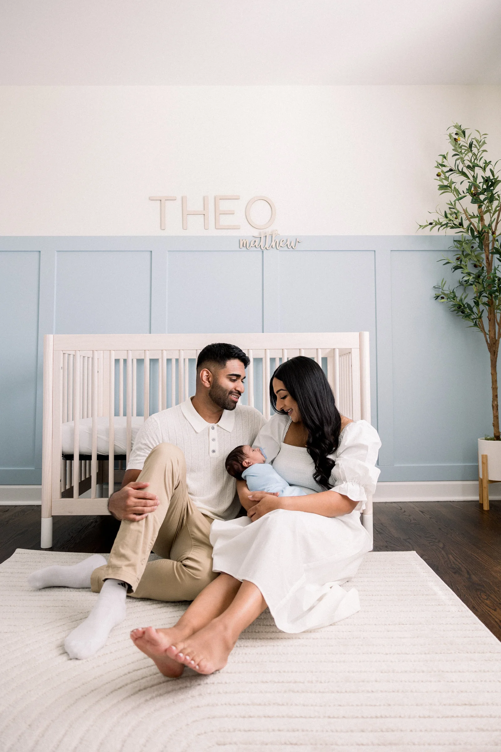Parents with their newborn son in his nursery at home